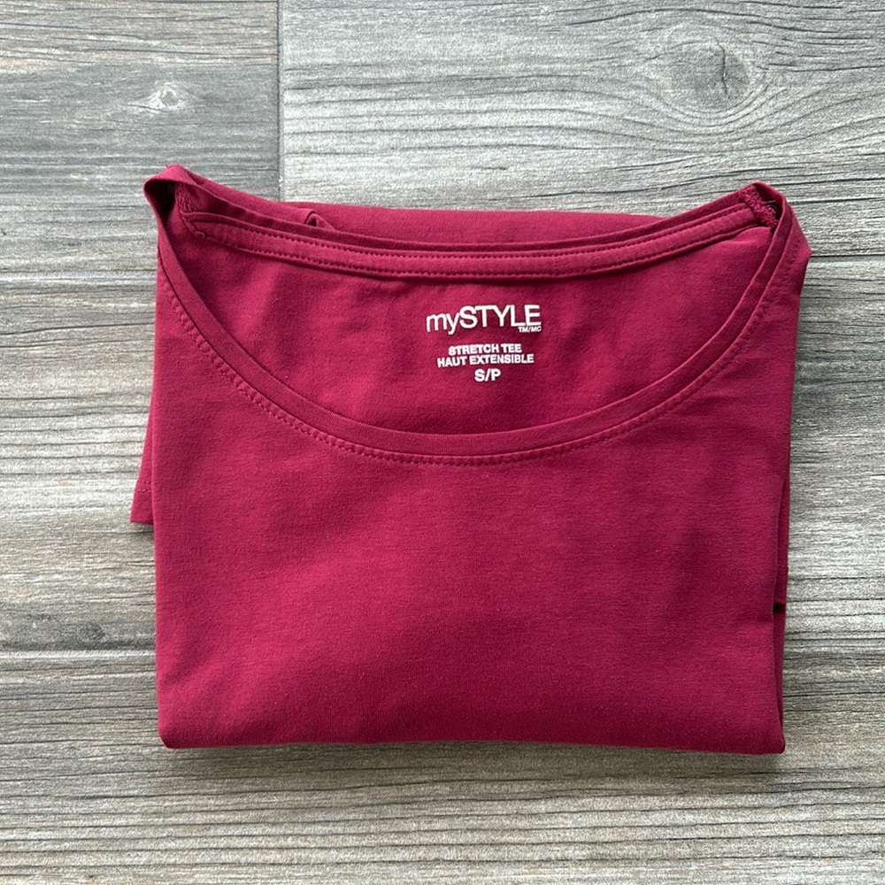 Woman’s long sleeved stretch tee. Has a small faint stain. Shown in photos.